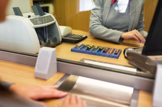impiegato-che-conta-denaro-contante-all-ufficio-della-banca-85630563